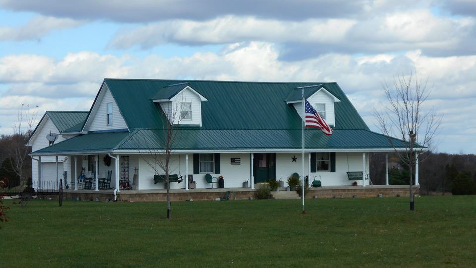 Steel Roofing Residential a white house with a green roof